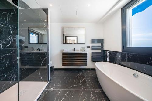 une salle de bain avec une baignoire et un lavabo dans l'établissement Suite Horizon Penthouse d'exception avec Vue Mer à Cannes, à Cannes