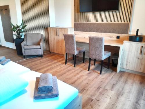 a room with a table and two chairs and a television at Gasthof Steinbichler in Nussdorf am Attersee