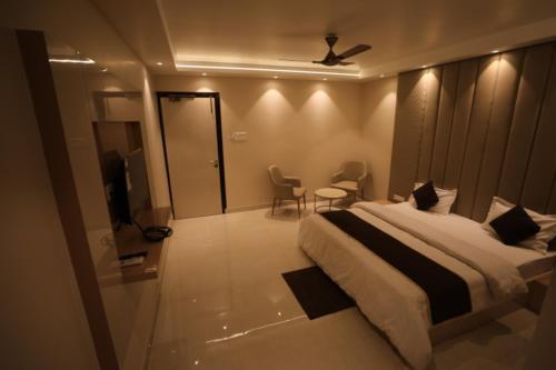 a bedroom with a bed and a tv in a room at Hotel Maya crystal in Juhi Bari