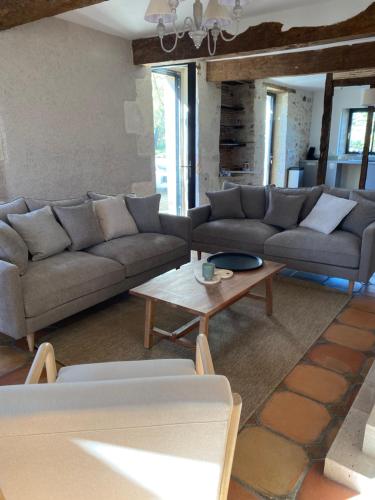 a living room with couches and a coffee table at Le gîte de Mauvielle in Solomiac