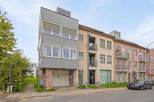 an apartment building on a street with a car at Ruim 2 slaapkamer appartement met parking nabij NAVO in Machelen