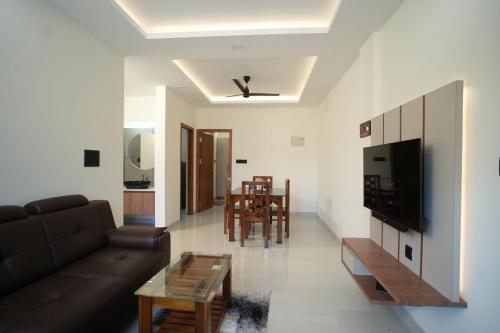 a living room with a couch and a table at Theeram Residency in Iringal