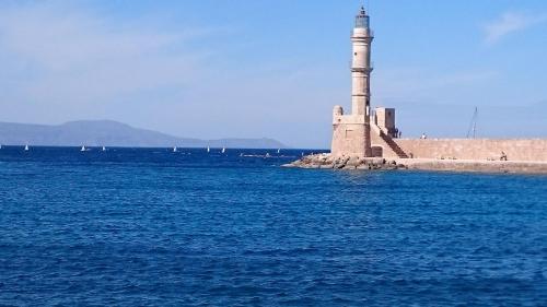 a lighthouse on a island in the water at Mythos- Platanias- Hotel -Apts in Plataniás