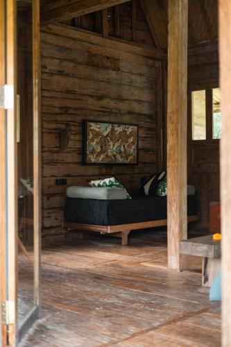 a bedroom with a bed in a wooden cabin at Desa Seni Baturiti in Baturiti