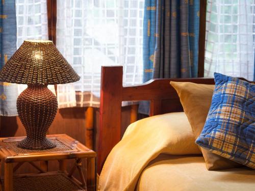 a lamp sitting on a table next to a bed at El Septimo Paraiso in Mindo