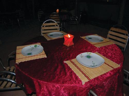 a table with a red table cloth and plates on it at Gite Souss in Oulad Teima