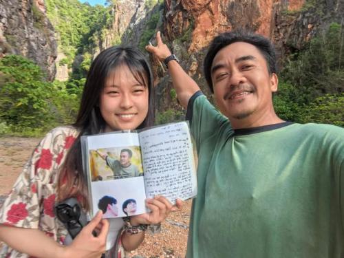 a man and a woman holding up a book at โฮมสเตย์บ้านนายสิงโตเขาคูหา in Ban Khu Ha Nai (1)