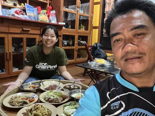 a man and a woman sitting at a table with plates of food at โฮมสเตย์บ้านนายสิงโตเขาคูหา in Ban Khu Ha Nai (1)