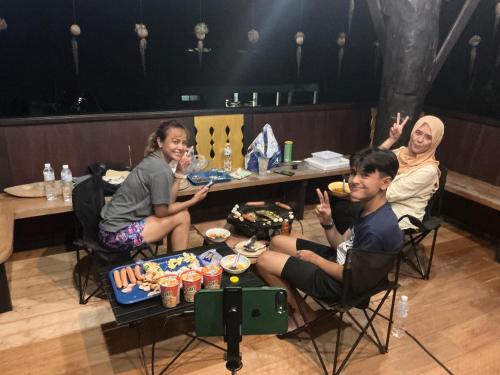 a group of people sitting around a table with food at โฮมสเตย์บ้านนายสิงโตเขาคูหา in Ban Khu Ha Nai (1)