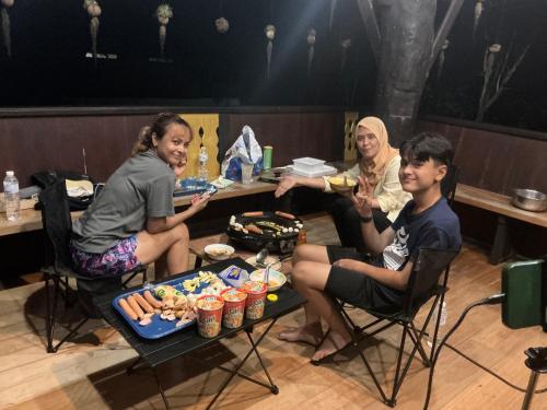 a group of people sitting around a table eating food at โฮมสเตย์บ้านนายสิงโตเขาคูหา in Ban Khu Ha Nai (1)