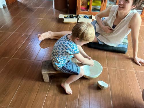 a young boy playing with a bowl on the floor at โฮมสเตย์บ้านนายสิงโตเขาคูหา in Ban Khu Ha Nai (1)