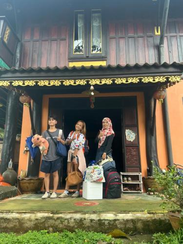 a group of people standing outside of a house at โฮมสเตย์บ้านนายสิงโตเขาคูหา in Ban Khu Ha Nai (1)