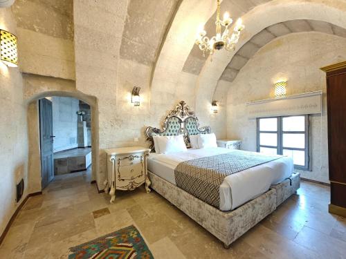 a bedroom with a king sized bed in a large room at Karlık Cave Suite Cappadocia in Uchisar