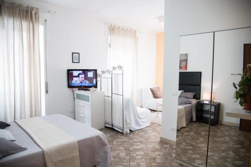 een slaapkamer met een bed en een tv en een bank bij Casa Alberone in Rome