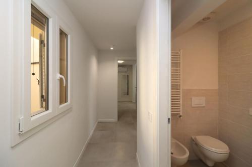 bagno bianco con servizi igienici e finestra di Benedetta suite in florence a Firenze