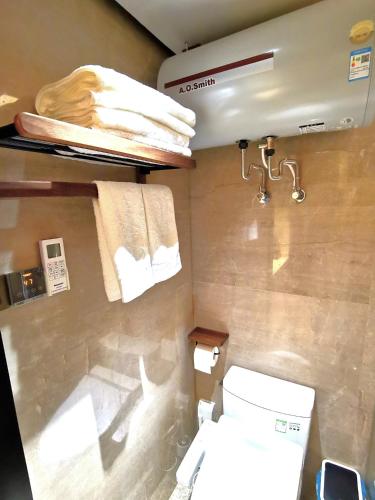 a bathroom with a toilet and a sink and towels at Interact China Fine Condo - Shenzhen Bay in Shenzhen