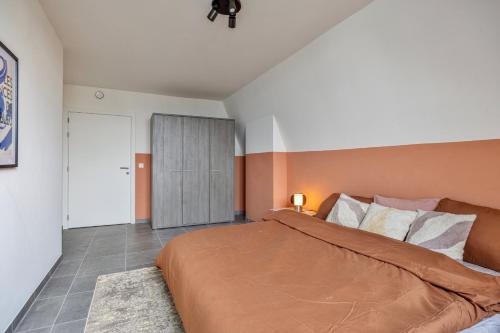 a bedroom with a large bed and a door at Ruim 2 slaapkamer appartement met parking nabij NAVO in Machelen