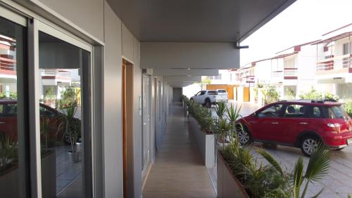 a red car parked outside of a building with plants at Vitrali Suite in Copiapó