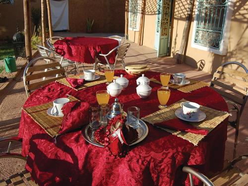 a table with red table cloths and pitchers on it at Gite Souss in Oulad Teima