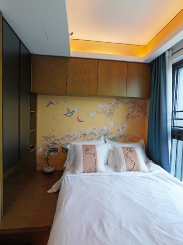 a bedroom with a white bed with butterflies on the wall at Interact China Fine Condo - Shenzhen Bay in Shenzhen