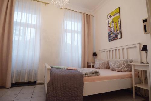 een slaapkamer met een bed en 2 ramen bij Feel at Home 2 in Heidelberg