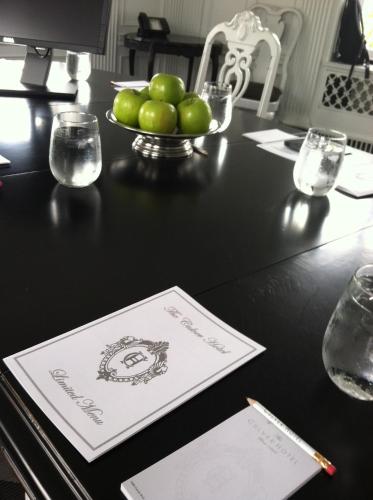a table with a plate of green apples on it at The Culver Hotel in Los Angeles