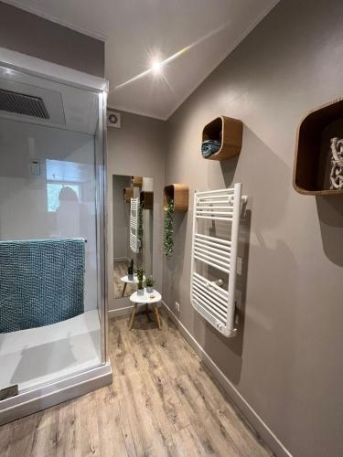 La salle de bains est pourvue d'une douche à l'italienne et d'une cabine de douche en verre. dans l'établissement Maison de village tout confort avec piscine, à Laugnac