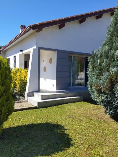 a white house with a garden and trees at Maison Cozy 2 à 6 personnes Option Balneo in Nay