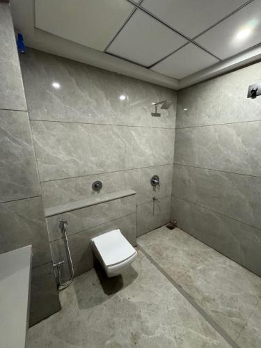 a bathroom with a white toilet in a room at Adarsh Hotel in Anand