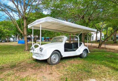 an old white car parked in a park at Maasai Koroga Hotel & Apartments in Mombasa