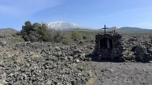 an old stone chapel with a cross on a mountain at Chalet Contrada Difesa in Bronte