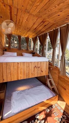 a bedroom with two bunk beds in a wooden room at Treecasa Resort in Sunāri