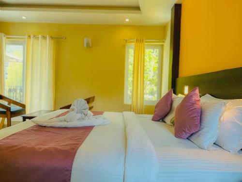 a bedroom with a large bed with towels on it at The Heights Munnar in Munnar