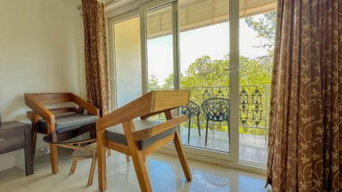 a desk and chair in a room with a window at The Heights Munnar in Munnar