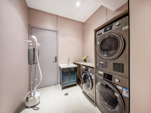 a laundry room with two washing machines and a sink at Yiwu Yunjing Hotel in Yiwu