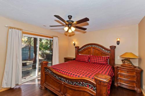 Un dormitorio con una cama y un ventilador de techo. en Big 10 Luxury Cabin/Walk to Snow Summit- HotTub, en Big Bear Lake