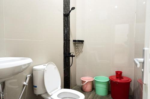 a bathroom with a white toilet and a sink at Palma Villa Bumi Dieng Indah in Kertosobo