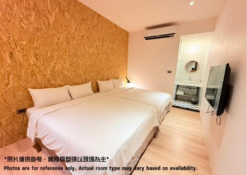 a bedroom with a large white bed and a television at Let's Hostel in Kaohsiung