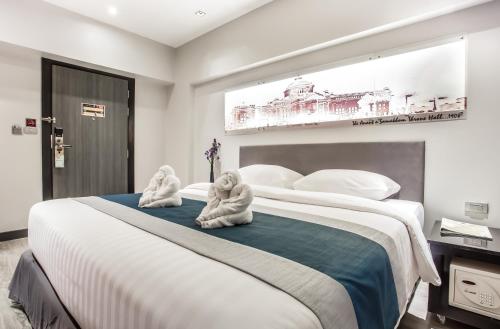 Postel nebo postele na pokoji v ubytování Nouvo City Hotel