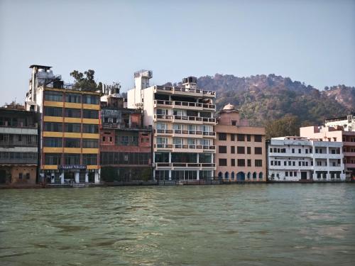 a group of buildings next to a body of water at Gauri Gangaa in Haridwār