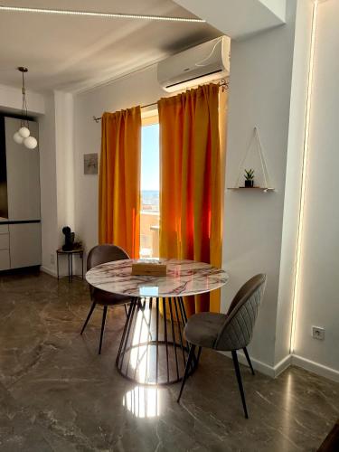 a dining room with a table and chairs and a window at Aqua Studio Craiova in Craiova