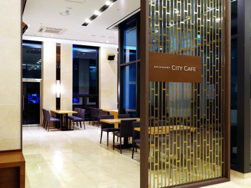 a lobby of a city cafe with tables and chairs at ON City Hotel in Cheonan