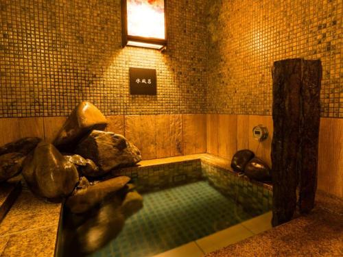 a pool of water in a bathroom with a window at Dormy Inn Premium Wakayama Natural Hot Spring in Wakayama