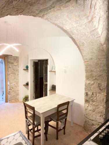 a table and chairs in a room with a stone wall at San Nicola Ospitalità Diffusa in Trentinara