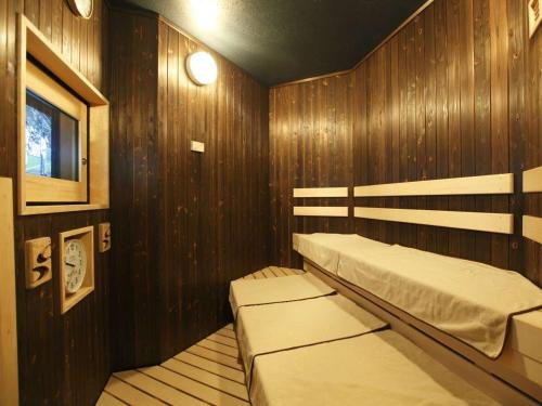 a bedroom with wooden walls and two beds in it at Dormy Inn Premium Wakayama Natural Hot Spring in Wakayama