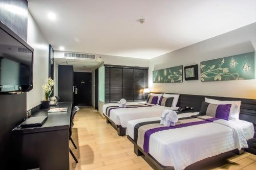 Postel nebo postele na pokoji v ubytování Nouvo City Hotel