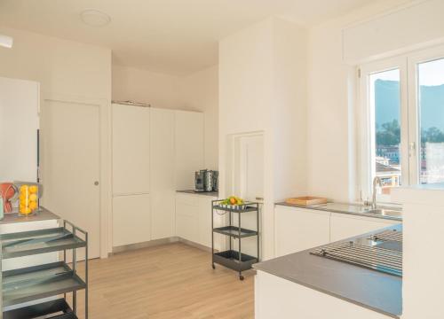 eine Küche mit weißen Schränken und einer Arbeitsplatte in der Unterkunft Duplex Lakeside Penthouse in Porto Valtravaglia