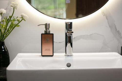 a bottle of soap sitting on a bathroom sink at Aurora Oriental Hotel in Hanoi