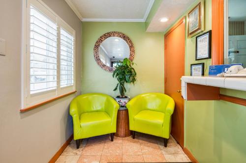 a waiting room with two yellow chairs and a mirror at Americas Best Value Inn Richmond in Richmond