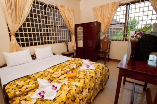 a bedroom with a bed with flowers on it at Okay Guesthouse Siem Reap in Siem Reap